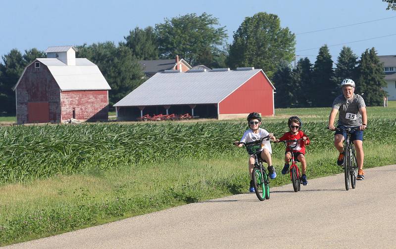 Maddux, Eli and Jared Bell of Hennepin, ride their bikes past a barn along 2250 East Street during the Z Tour event on Saturday June 21, 2025 in Princeton. Z Tour is an annual charity event supports the Zearing Child Enrichment Center, a not-for-profit organization. The event offers various paved road routes, including 10, 30, 65 mile loops. Riders begin and end at Zearing Park.