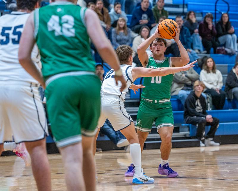 Evan Cox (10) of Dwight holds ball over head searching for open teammate as Eli Gerdes (23) of Fieldcrest stands guard on Monday, December 15, 2025 at Fieldcrest High School in Minonk.