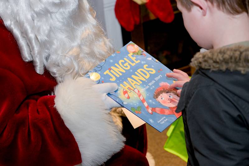Harrison La Gesse, 7 of South Elgin receives a storybook from Santa during his visit to Santa’s Workshop in Geneva on Saturday, Dec 20, 2025 in Geneva.