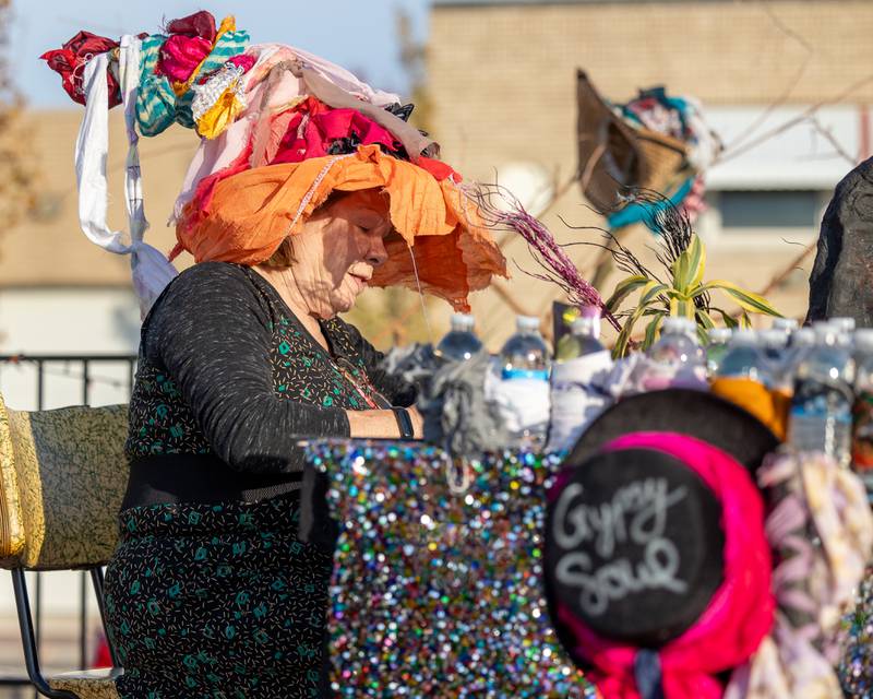 Collette Spears of Artful Hook draws on business cards at the annual Witches Walk on Friday, Oct. 17, 2025, at the Market on Mill in Utica.