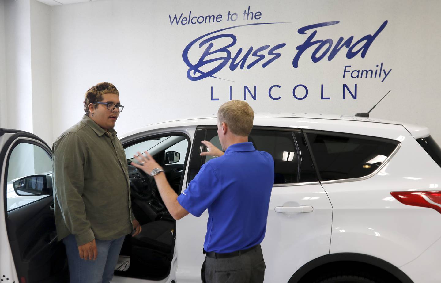 Daniel Avila talks with Drew Buss of Buss Ford on Wednesday, June 18, 2025, at the dealership in McHenry while picking up his car. Avila's teacher, Kate Knaack, created a GoFundMe to help the 2025 McHenry High School graduate buy a car, allowing him to go to McHenry County College this fall, work this summer, and help his dad care for his 8-year-old twin brothers following his mother's death in February 2024.