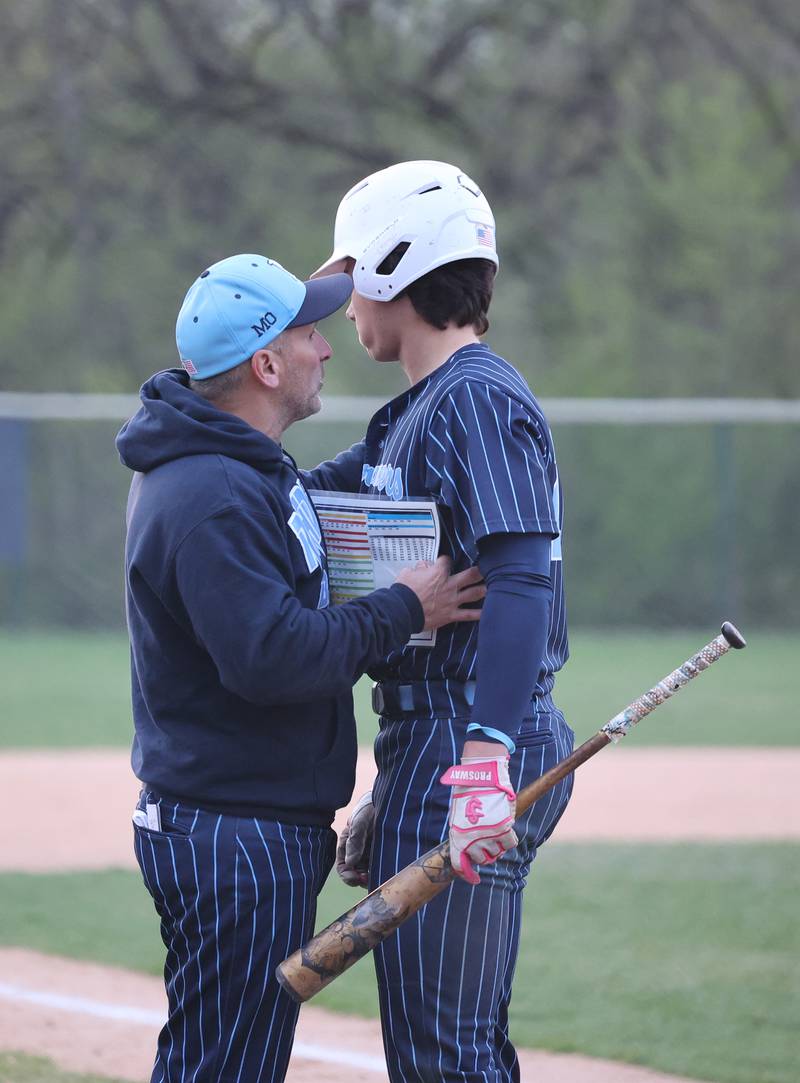 Nazareth head coach Lee Milano talks to Jaden Fauske (21) right before his grand slam home run in the sixth inning during the varsity baseball game between Benet Academy and Nazareth Academy in La Grange Park on Monday, April 24, 2023.