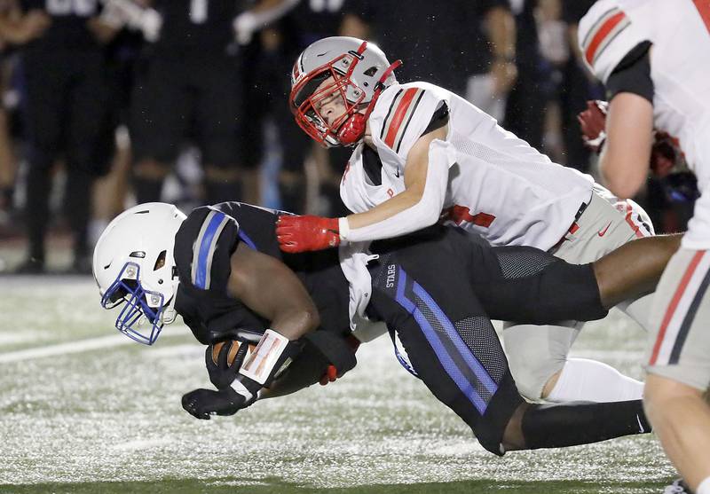 Palatine's Jacob Stark (4) brings down St. Charles North's Joell Holloman (11)  Friday August 25, 2023 in St. Charles.