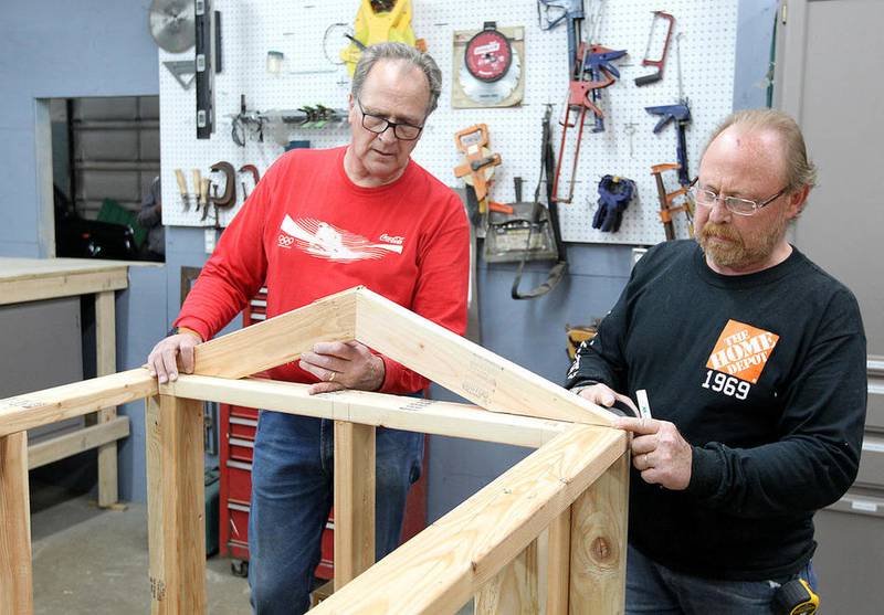Tom May (left) and Craig Lowery, volunteers from Home Depot, measure roof truss pieces Friday for one of the structures for a Safety Town at the McHenry Parks and Recreation maintenance facility in McHenry. The miniature town will feature programs during the summer on a range of topics including bicycle, pedestrian, school bus, fire, water, railroad, playground and pet safety to educate young people in a realistic setting.