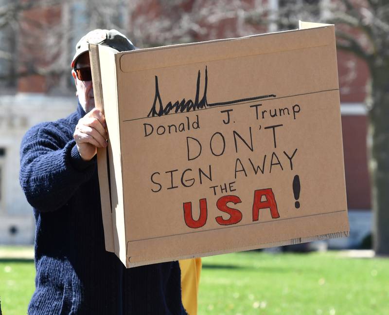 A demonstrator holds a sign at the No Kings rally on Saturday, March 28, 2026, in downtown Oregon, Illinois.