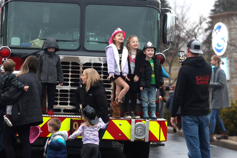 Children swarm a fire truck and pose for pictures during a Read & Eat Fries With a Firefighter event Thursday, March 16, 2023, at the Culver’s in Huntley.