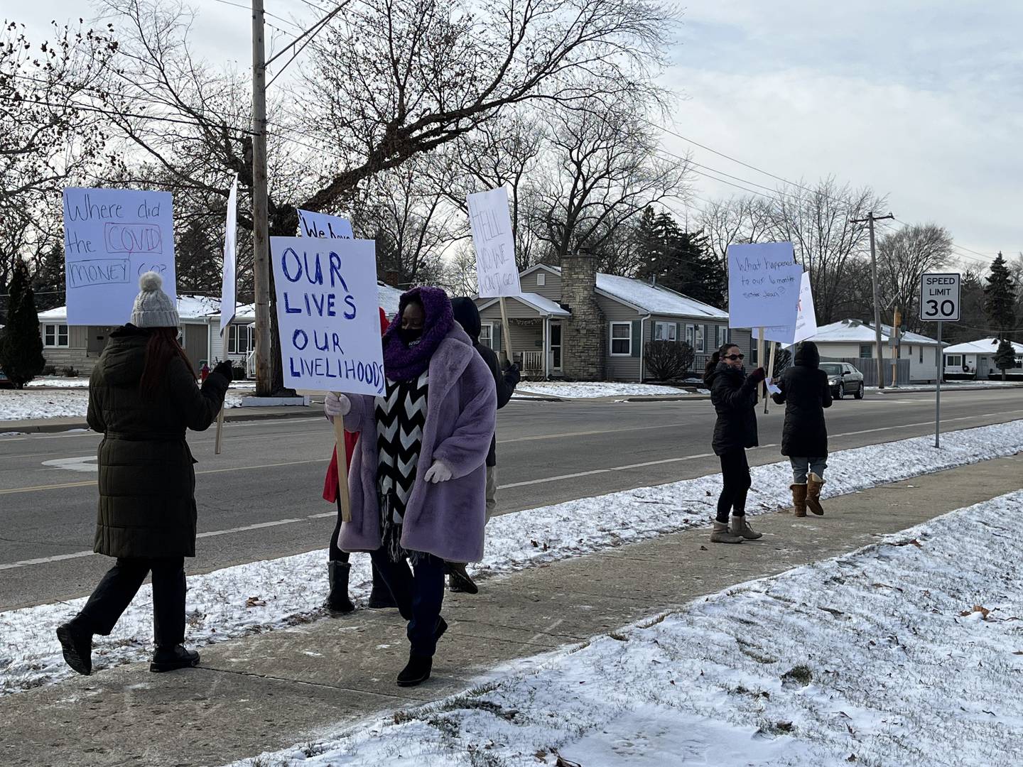 Joliet mayoral candidate Tycee Bell (center) holds a sign that says, "Our lives our livelihood," while attending a rally held on Monday, Dec. 19, 2022, to keep Our Lady of Angels Retirement Home open. The facility is scheduled for closure on Feb. 28, 2023.