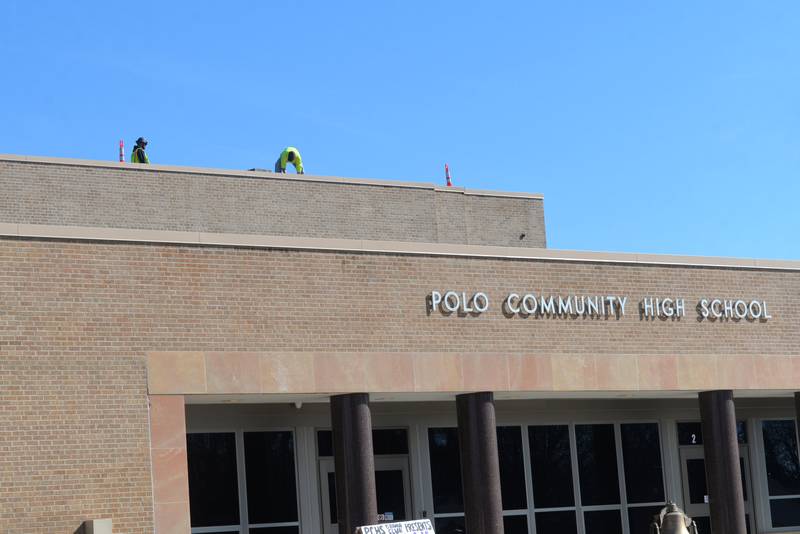Workers unload solar panel materials on the roof of Polo Community High School on Saturday, March 2, 2024.