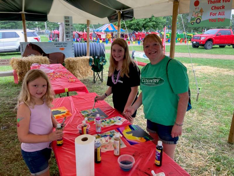 Avery, Kiryn and Carla Schaer, of Sparland enjoy craft time under the tent at ImAGination Acres during the 100th Marshall-Putnam Fair.