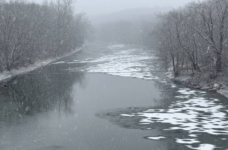 Snow falls on a partially frozen Vermilion River on Thursday, Jan. 2, 2025 near Jonesville.