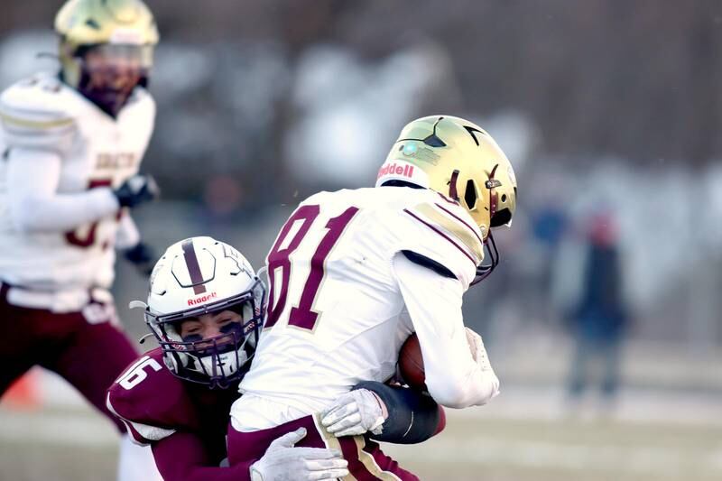 Prairie Ridge’s Dominic Creatore wraps up St. Ignatius’ Albert Connor in Class 6A football playoff semifinal action at Crystal Lake on Saturday.