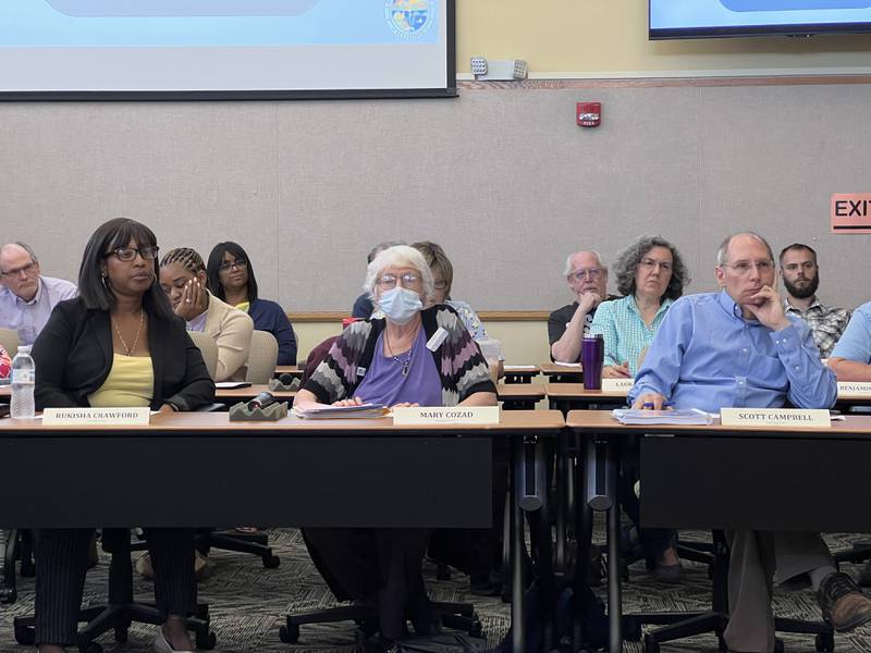 Seated in the front row of the DeKalb County Board, Democratic County Board members Rukisha Crawford, Mary Cozad and Scott Campbell, from Districts 6, 10 and 7, respectively, listen to public comments during a DeKalb County Board meeting on June 26, 2024.