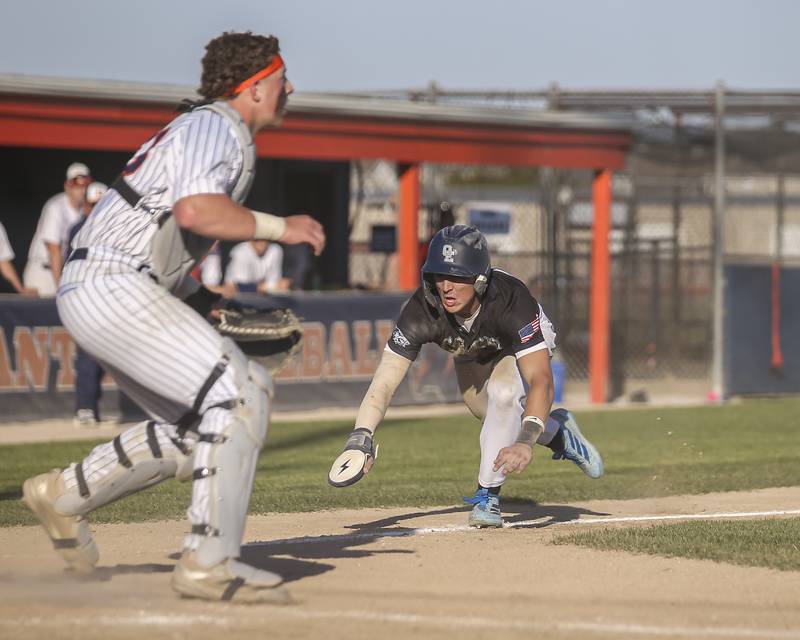 Oswego East's Dominic Battista (14) goes into his slide at home during baseball game Oswego East at Oswego.  May 14, 2026 in Oswego.