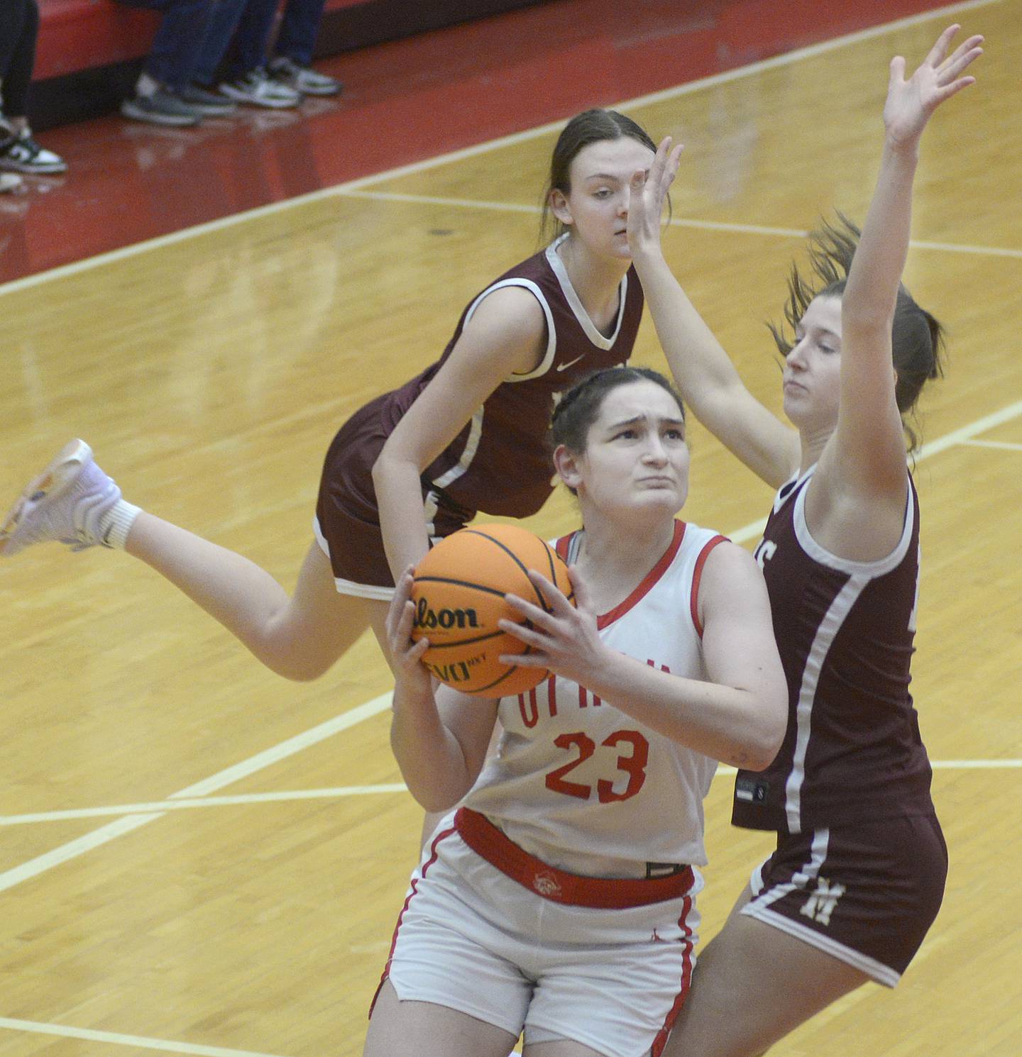 Ottawa’s Mary Stisser gets between Morris’s Lily Hansena and Tessa Shannon on a drive to the basket in the 4th period Saturday at Ottawa.