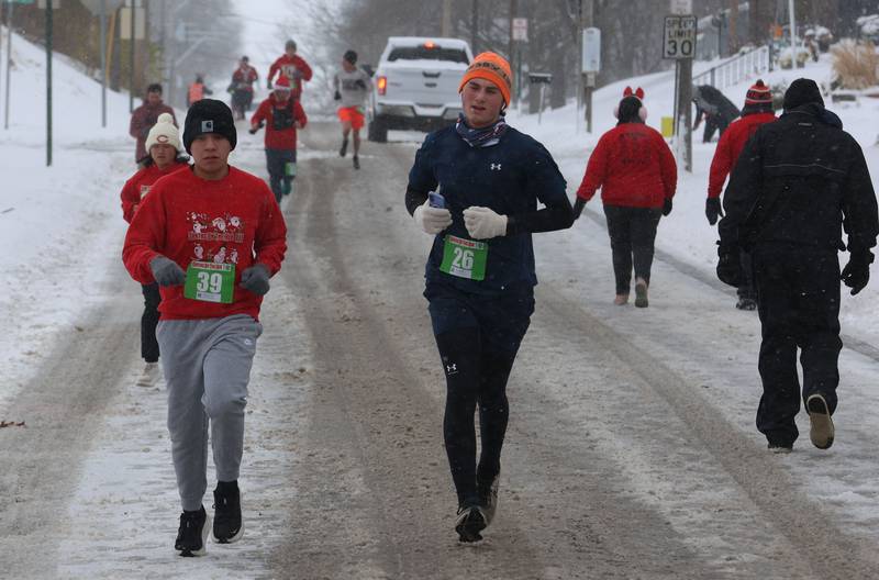 Marcos Castro and Ryne Bubela lead a pack of runners during the Santas on the Run 5K and one-mile walk on Saturday, Nov. 29, 2025 in Spring Valley.