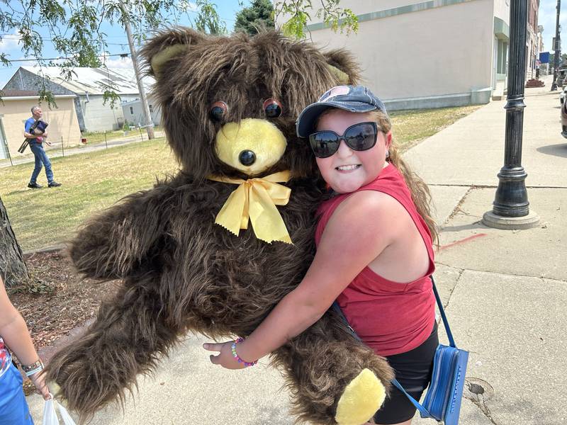 Taytum Coulter, 10, of Oregon, hugs the big teddy bear she received as the Oregon VFW/American Legion float passed by her family during the Let Freedom Ring parade on Friday, July 4, 2025 in Mt. Morris. Taytum's grandfather, Robert, is a member of Oregon VFW OPost 8739 and was driving the truck that was pulling the float. Taytum was excited to receive the bear stating: "I didn't know it was on the float".
