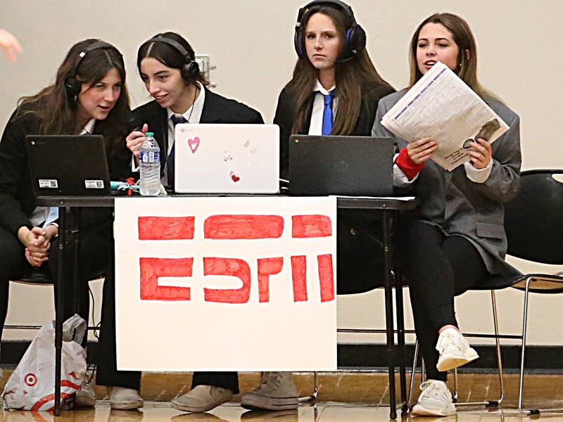 Hall High School girls (from left) Liliana Heredia, Abby Kaszynski, Clara Jablonski and Cece Verucchi act out a skit where they pretend to be on ESPN during the game against St. Bede on Monday, Nov. 28, 2022 at Hall High School in Spring Valley.