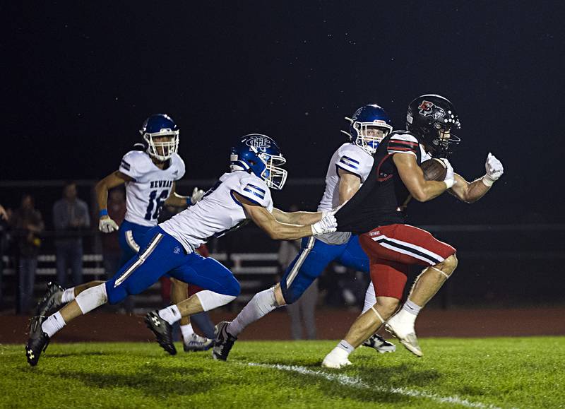 Newman’s Mac Hanrahan grabs the jersey of Erie-Prophetstown’s Justus Hough Friday, Sept. 22, 2023 in a game at Erie.