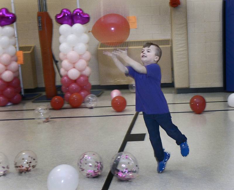Grayson Bayer chases balloons during a Valentine's Family Fun Day event Friday, Feb. 14, 2025, at Lincoln Elementary School in Ottawa.