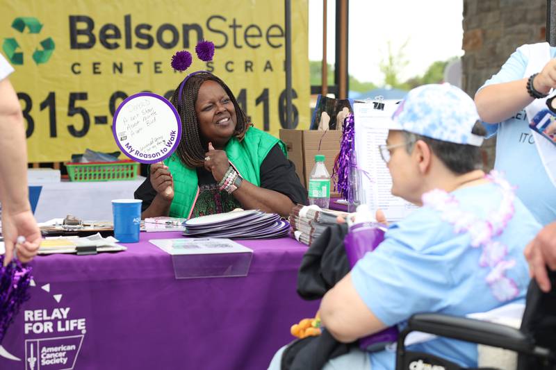 Volunteer Lovice Brinkman, of Kankakee, shares her reasons to walk on a sign with participants during the Relay for Life of Kankakee County on June 14, 2025, at The Grove in Bourbonnais.