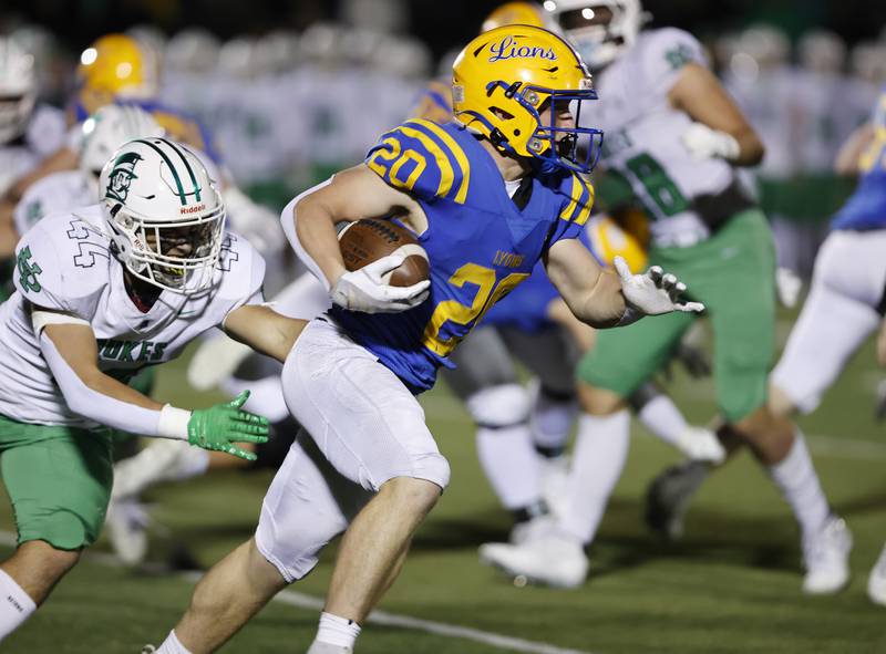 Lyons' EJ Kuhlman (20) runs the ball during the varsity football first-round 8A playoff game between York and Lyons Township on Friday, Oct. 31, 2025 in Western Springs, IL.