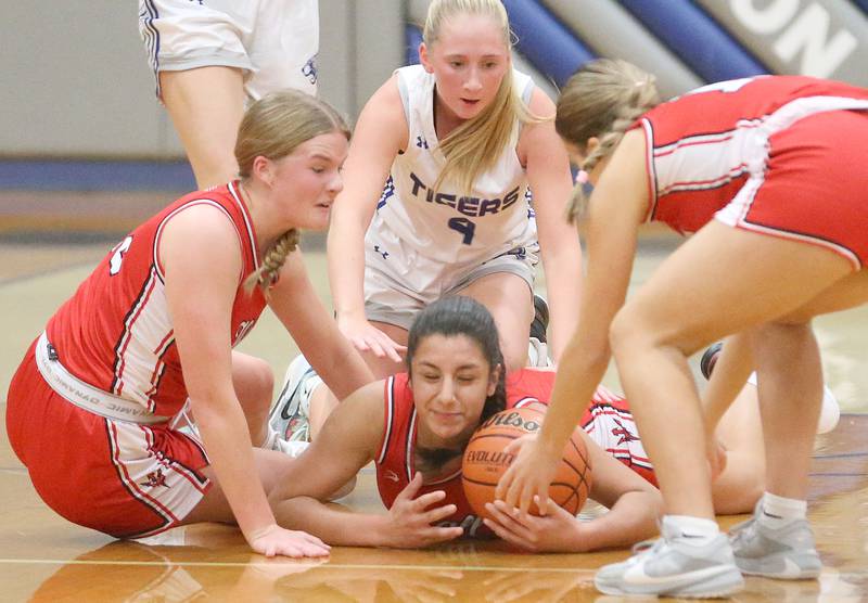 Hall's Natalia Zamora (bottom) picks up a loose ball with the help of teammates Caroline Morris and Bella Orozco as Princeton's Paige Jesse arrives late to the play during the Princeton Holiday Girls Basketball Tournament on Friday, Nov. 23, 2024 at Princeton High School.