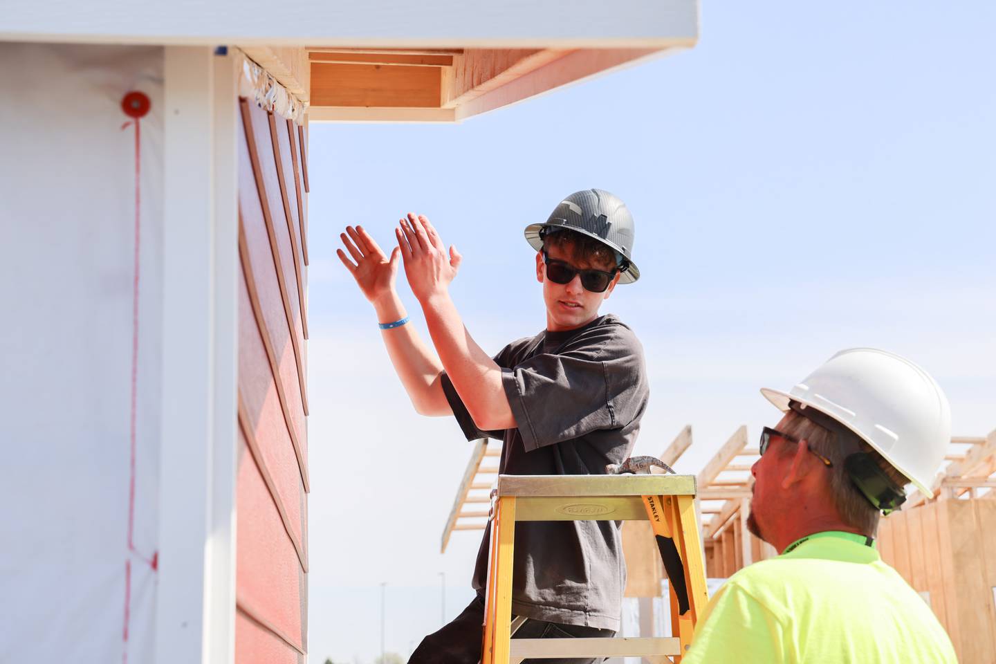 Cooper Olszewski, left, Huntley High School sophomore and David Arnold of Westlake Royal Building Products work on a GeoCon build in Huntley Friday, May 8, 2026.