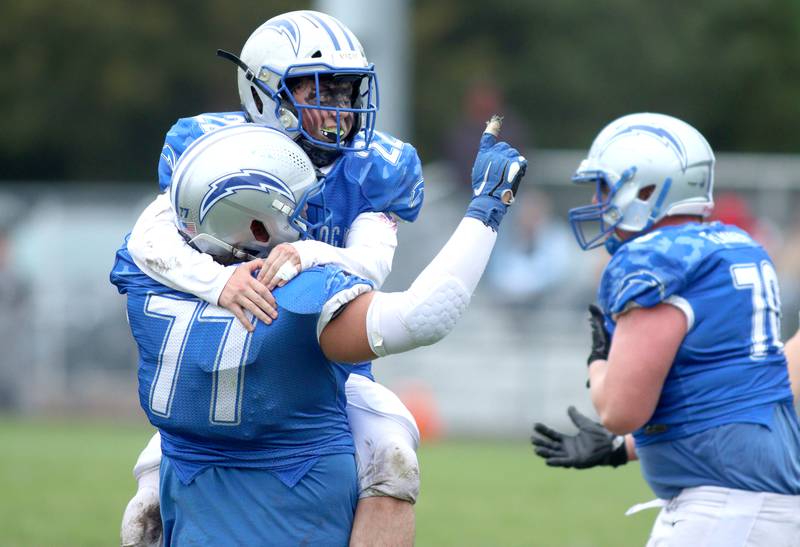 Woodstock’s Jackson Canty (22) and Bode Pedersen (77) celebrate late in a win over Ottawa in varsity football at Larry Dale Field on the campus of Woodstock High School Saturday.