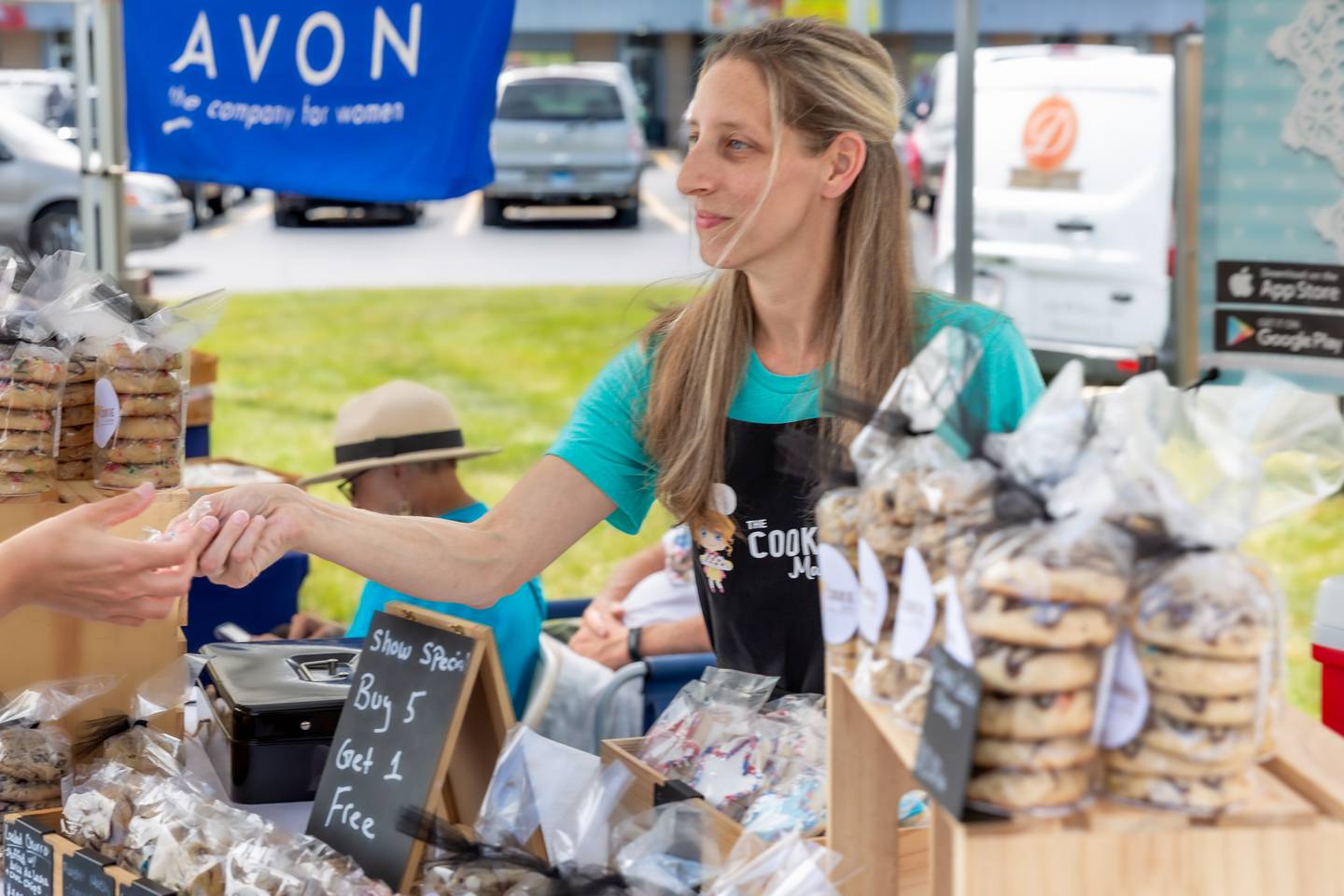 The Cookie Maker owner Heather Kratz hands out a cookie sample at the Winfield Farmer's Market in Winfield, IL.  July 3rd, 2024.