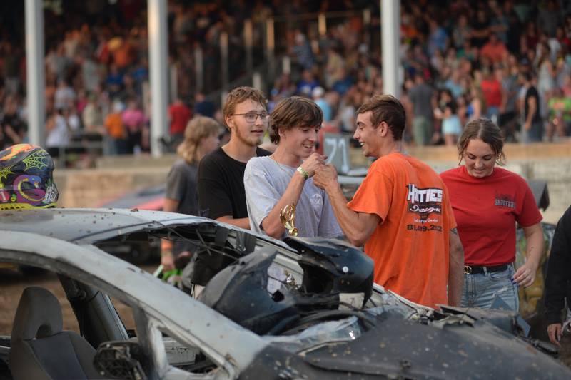 Buddy Fortune, 20, (right) fist bumps his brother Levi, 15, after they finished first and second in the compact heat of the Whiteside County Fair's demolition derby on Saturday, Aug. 19, 2023.