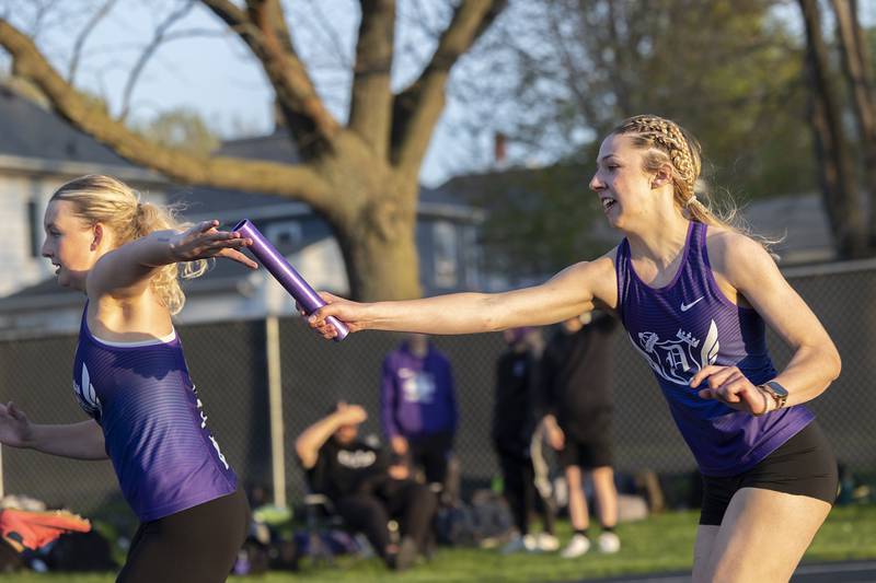 Dixon’s Emma Olson reaches back for the baton from Adeline Lohse in the 4x100 Thursday, April 25, 2024 at the Sterling High School Night Relays.