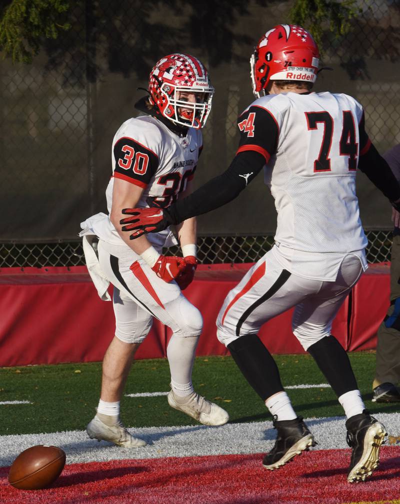 Maine South’s Mike Sajenko, left, celebrates his first of two fourth-quarter touchdowns with Andy Podolski during the Class 8A football semifinal game in Chicago Saturday.