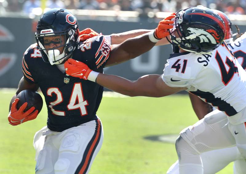 Chicago Bears running back Khalil Herbert stiff arms Denver Broncos linebacker Drew Sanders during their game Sunday, Oct. 1, 2023, at Soldier Field in Chicago.