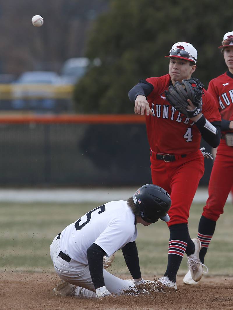 Huntley’s Ryan Quinlan tries to turn a double play as Crystal Lake’s Central’s Aidan Alig slides into second base during a Fox Valley Conference baseball game Wednesday, April 6, 2022, between Crystal Lake Central and Huntley at Crystal Lake Central High School.