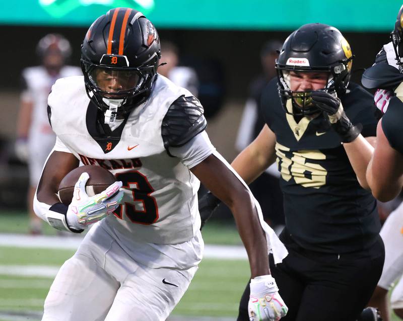 DeKalb's Davon Grant carries the ball with Sycamore's Adam Carrick in pursuit Friday, Aug. 29, 2025, during the FNBO Challenge in Huskie Stadium at Northern Illinois University.