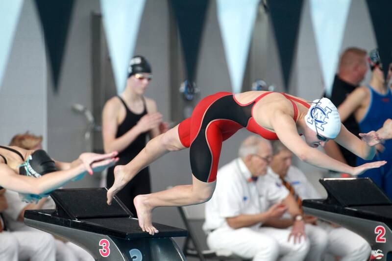 West Chicago co-op’s Claire Conklin takes off from the block for the 50-yard freestyle consolation heat during the IHSA Girls State Swimming and Diving Championships at the FMC Natatorium in Westmont on Saturday, Nov. 11, 2023.