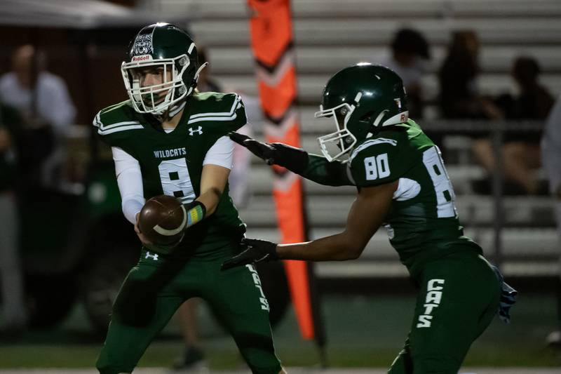 Plainfield Centrals Logan Beutel hands off the ball to Alex Garcia Ryder during a game against Plainfield East Friday Sept. 27, 2024 at Plainfield Central High School
