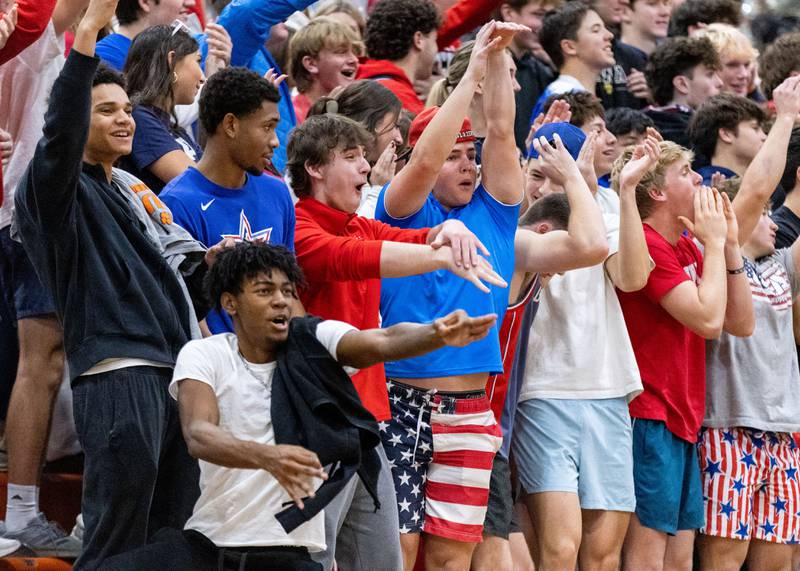 Wheaton Warrenville South fans cheer after their team scored a three-point field goal during a home game against Geneva High School on Tuesday, Dec. 3, 2024.