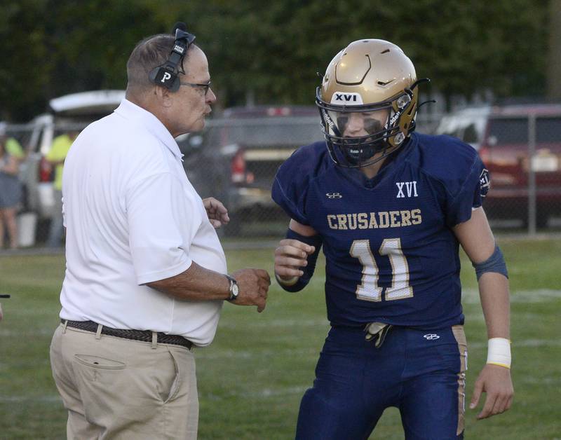 Marquette head coach Tom Jobst deliverers a play to QB Anthony Couch in the first quarter Friday against Madison.