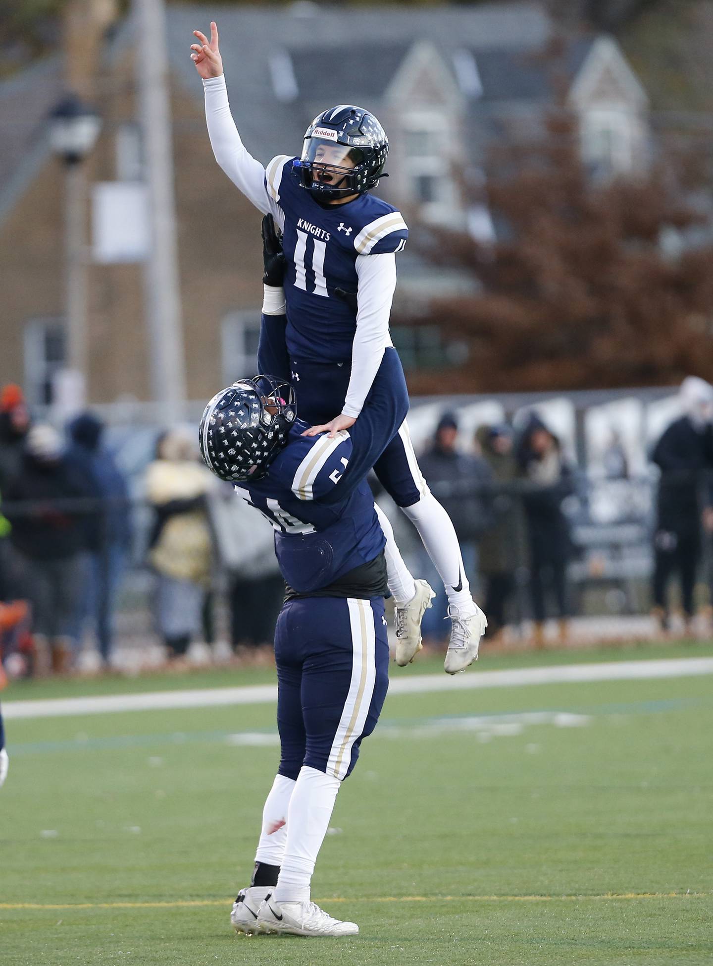 IC Catholic's Jayden Sutton (54) lifts Dennis Mandala (11) in celebration after a touchdown during the Class 3A varsity football semi-final playoff game between Byron High School and IC Catholic Prep on Saturday, Nov. 19, 2022 in Elmhurst, IL.