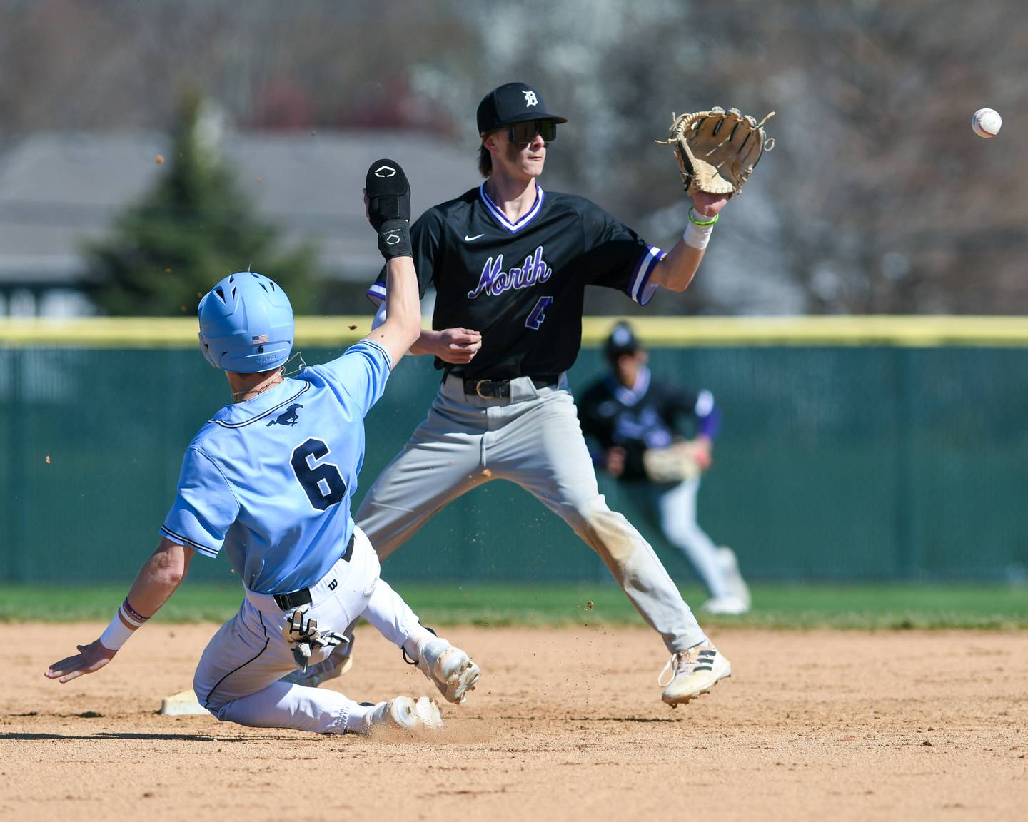 Downers Grove North’s Jude Warwick receives the ball in time to get  Downers Grove South’s runner  Will Potter (6) but wasn’t able to turn a double play on Saturday April 13, 2024 held at Downers Grove South.