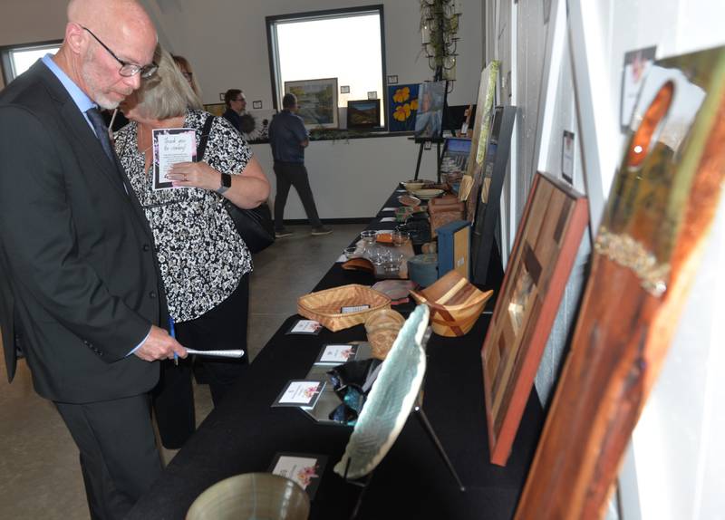 Mike Rock of Byron looks over some of the items at Art Dash, a fundraiser for Serenity Hospice & Home, on Wednesday, April 10, 2024 at River's Edge in Oregon.