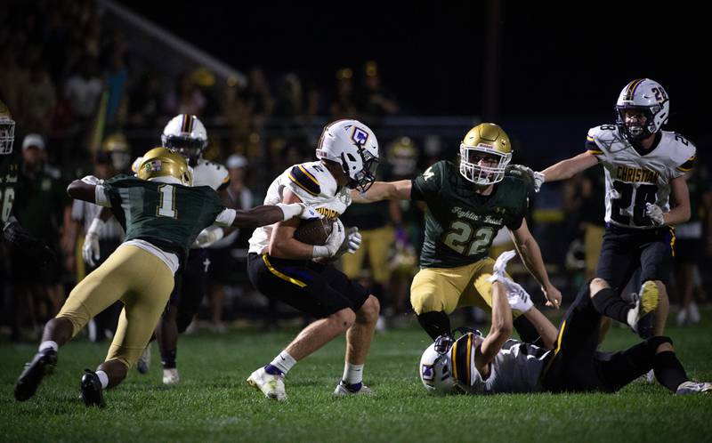 Bishop McNamara's Malachai Lee, left, and Rhys Landsmann, right, look to stop Chicago Christian's Josh Crawford, center, in a game on Friday, September 19, 2025.