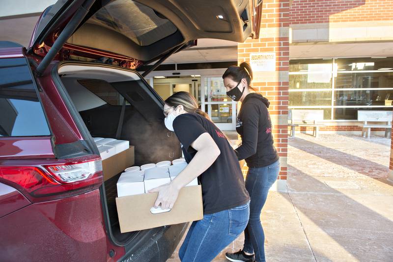 Taylor Troutman (left) and Jessi Marshall unload the boxes at the emergency entrance to KSB Hospital in Dixon.