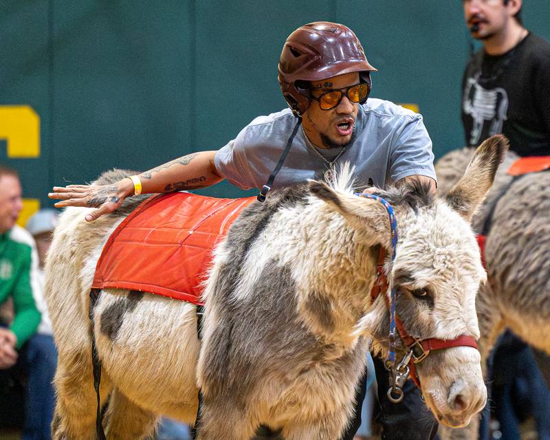 Member of the 'Village Church' team leads donkey down court in game of Donkey Basketball on Saturday, Feb. 7, 2026 at Seneca High School West Campus in Seneca.