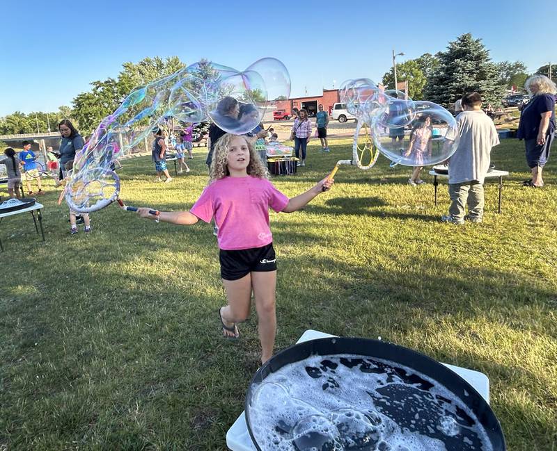 Talia Pope, 7, of Oregon, makes bubbles at the River's Edge Farmers Market in Oregon on Thursday, June 19, 2025. The bubble fun was provided by "Bubble Guy" Jason Kollom, who was sponsored by the Oregon Public Library. The Farmers Market is held Thursday nights 5-7:30 p.m. at 123 N. 2nd St., in Oregon.