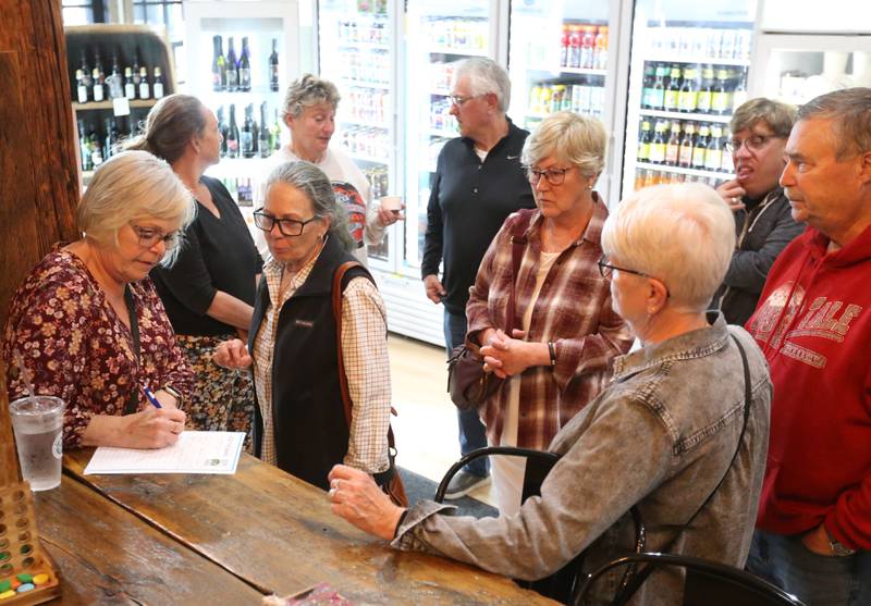 Maribeth Manigold (left) signs a petition with several others during a meeting  for keeping of Starved Rock name on Monday, April 29, 2024 at Bruce and Ollie's in Utica. The IDNR is looking at changing the name of Starved Rock.