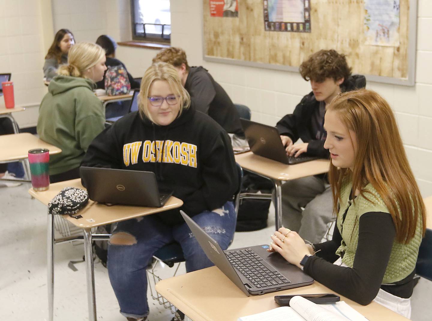 Seniors Sophia Meiners and Jaydin Beckel talk about their writing assignments during a dual credit composition class Wednesday, March 1, 2023, at Woodstock High School.