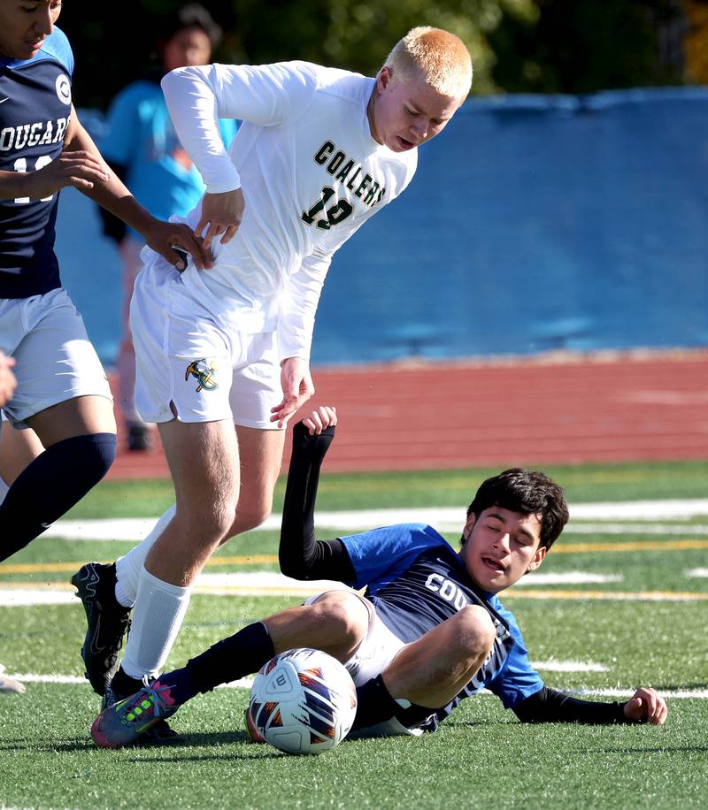 Coal City's Carsen Hart tries to avoid the slide tackle of Chicago Academy's Jhostyn Lemus Friday, Nov. 7, 2025, during their Class 1A state third place game at Hoffman Estates High School.