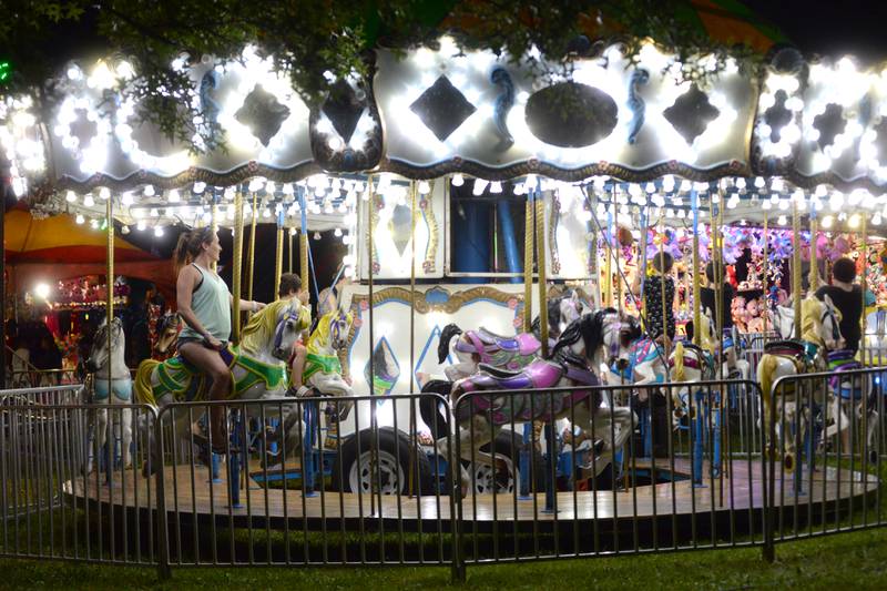 People ride the carousel at the Ogle County Fair carnival on Wednesday night, July 31, 2024.